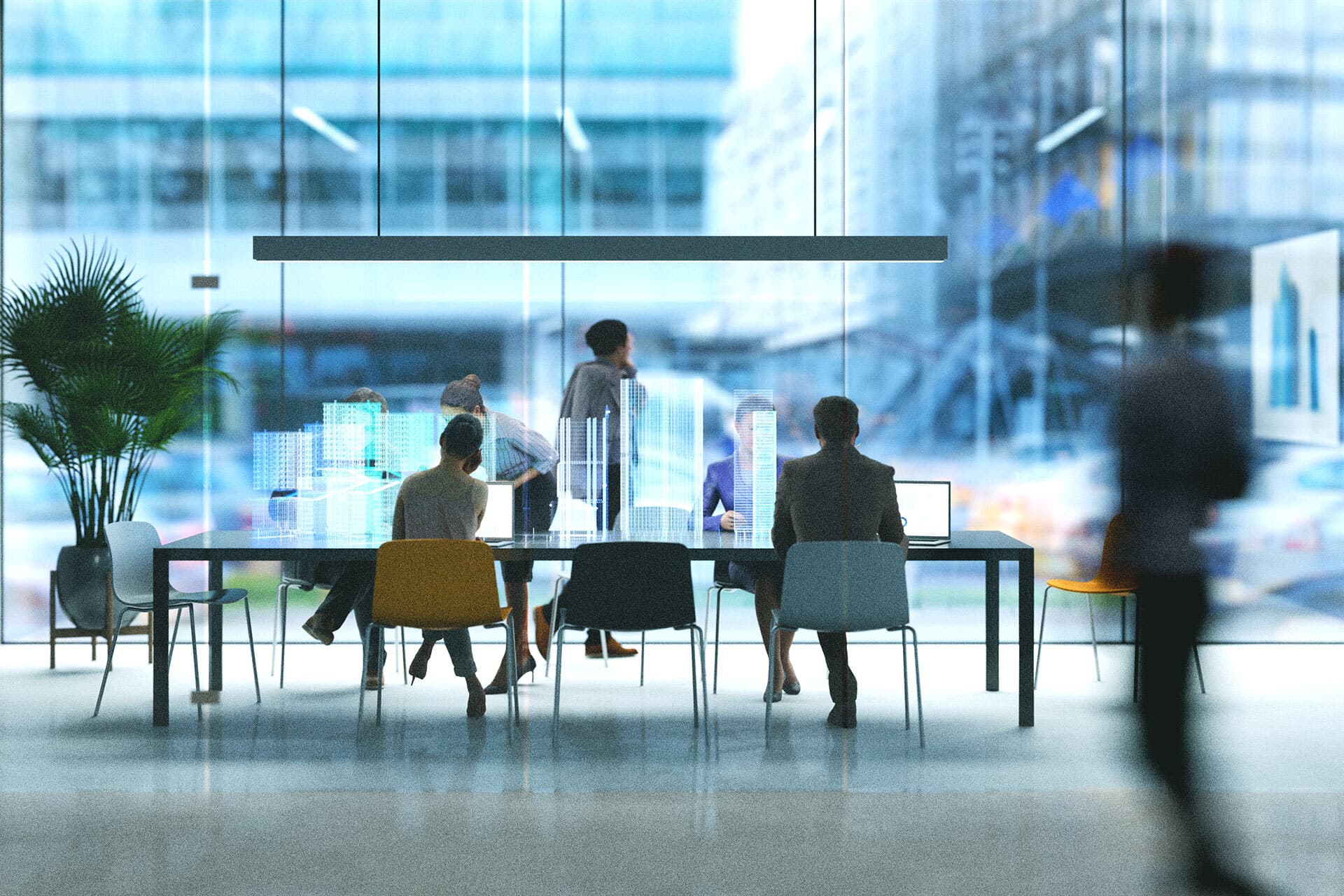 Workers in an office setting seated at a conference table, using visual technology